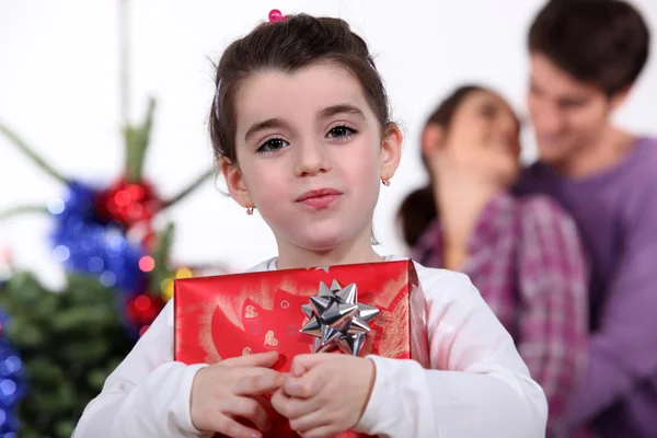 Ung flicka håller en gåva på juldagen — Stockfoto