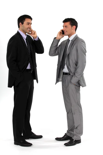 Young businessmen using cellphones — Stock Photo, Image