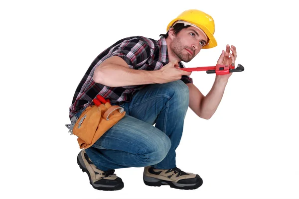 Homem usando uma chave de tubo para apertar um tubo — Fotografia de Stock