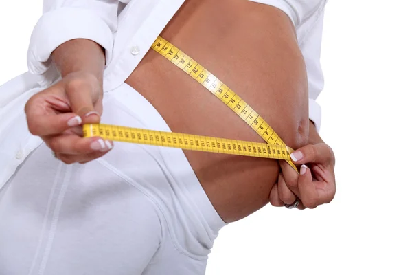 妊娠中の女性彼女の腹を測定 — ストック写真