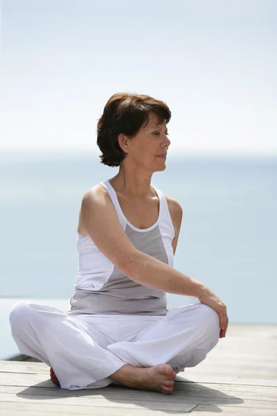 Ältere Frau praktiziert Yoga — Stockfoto