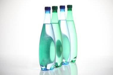 Four glass bottles standing in a row. clipart