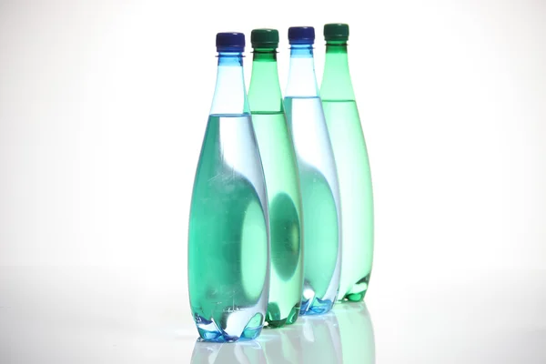 Cztery szklanych butelek stojących w rzędzie. — Zdjęcie stockowe