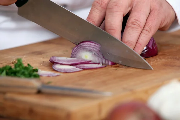 Chef cortando uma cebola vermelha — Fotografia de Stock