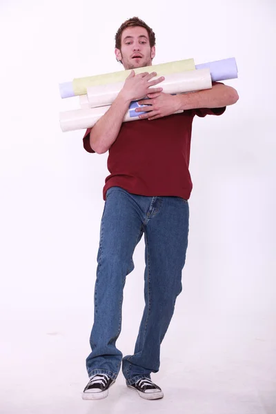 Homme chargé avec des rouleaux de papier peint — Photo
