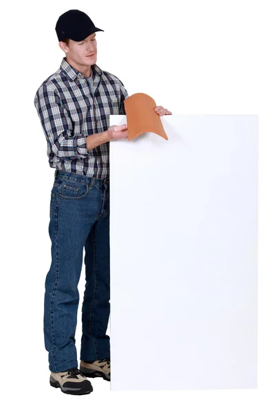 Roofer stood with tile and poster — Stock Photo, Image