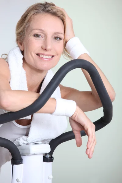 Kvinna på motionscykel — Stockfoto