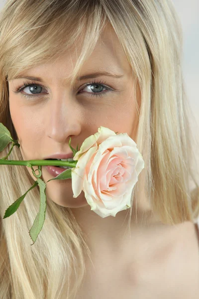 Femme blonde avec rose dans la bouche — Photo