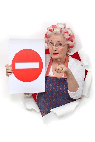 Пожилая женщина с катками для волос, предупреждающими — стоковое фото