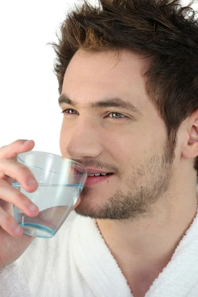 Jonge man die een glas water drinkt — Stockfoto