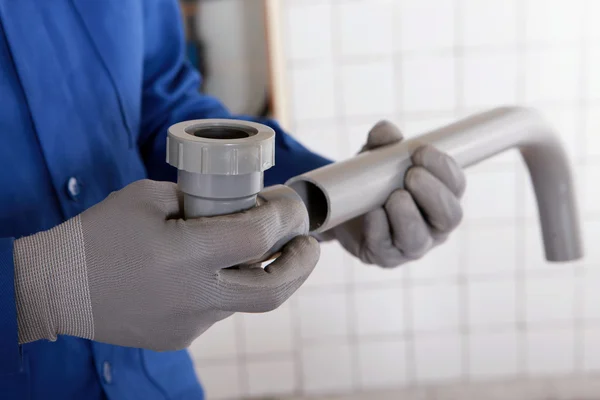 A plumber attaching two components together — Stock Photo, Image