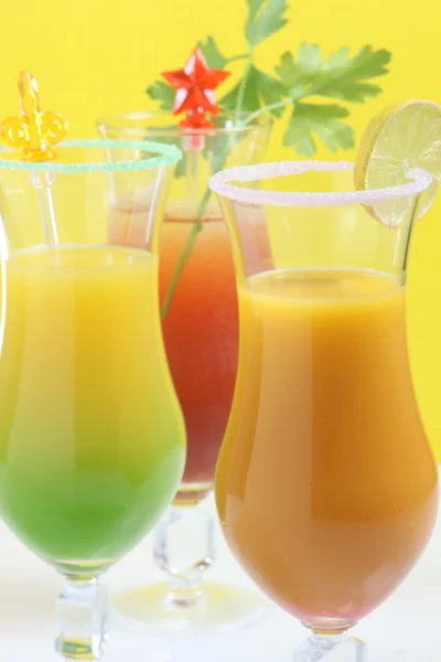 Drei Cocktails mit gelbem Hintergrund — Stockfoto