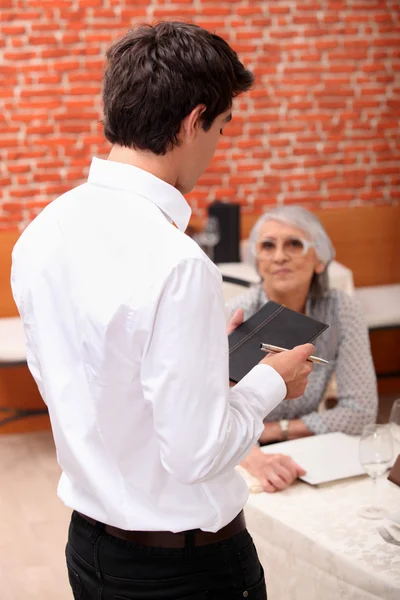 Young waiter taking orders — Stock Photo, Image