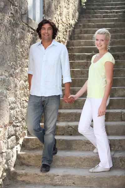 Couple descending downstairs in an old village — Stock Photo, Image
