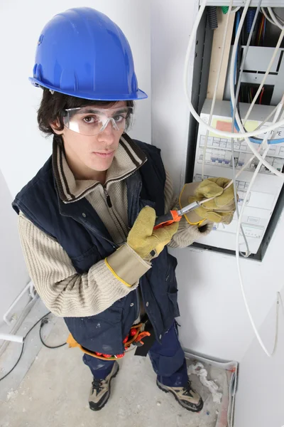 Young electrician stood by fuse box — Stock Photo, Image