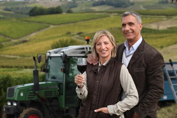 Фермерская пара стояла в поле перед трактором — стоковое фото