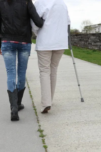 Женщина помогает старшему ходить — стоковое фото