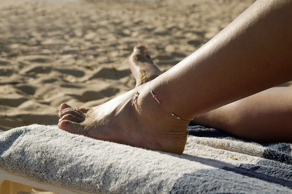 Жінка лежить на шезлонгу на пляжі — стокове фото