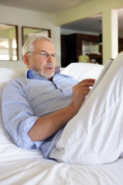 Älterer Mann beim Kreuzworträtsel in einem Magazin — Stockfoto