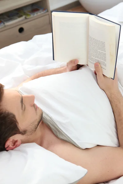 Άνθρωπος ανάγνωση στο κρεβάτι — Φωτογραφία Αρχείου