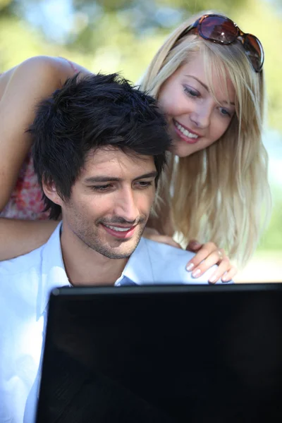 Casal jovem olhando para um laptop — Fotografia de Stock