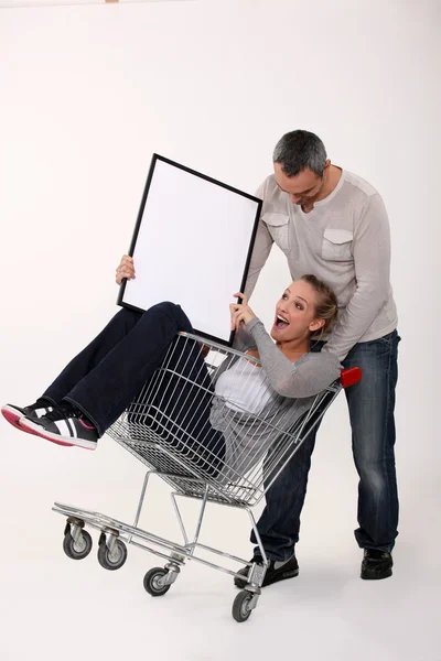 Couple with trolley holding picture frame — Stock Photo, Image