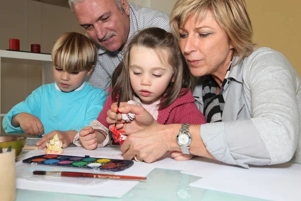 Бабушка и дедушка рисуют вместе с внуками — стоковое фото