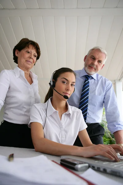 Business at a laptop with headset — Stock Photo, Image
