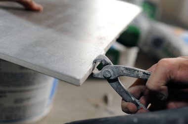 Man cutting a tile to size clipart