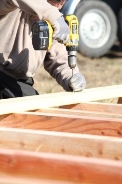 Builder using a cordless drill clipart