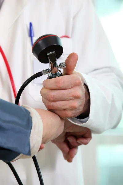 Médico midiendo la presión arterial de un paciente —  Fotos de Stock