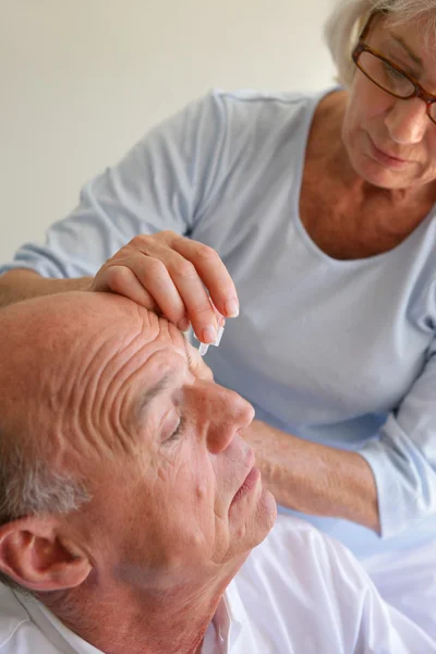 Wife helping husband with eye drops — Stock Photo, Image