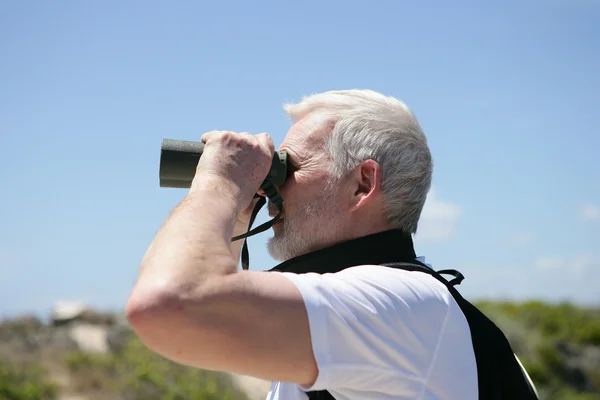 Muž se dívá dalekohledem — Stock fotografie