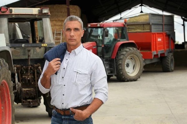 Фермер стоял перед тракторами — стоковое фото