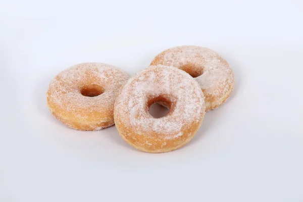 Три сладких пончика на белом фоне — стоковое фото