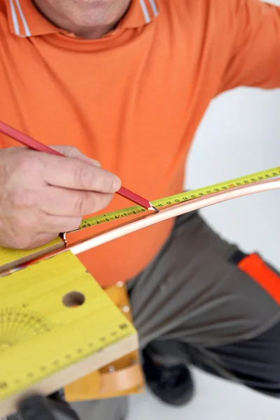 Travailleur mesurant tube de cuivre — Photo