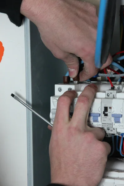 Electrician wiring a fuse box — Stockfoto