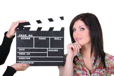 A woman posing near a movie clap clipart