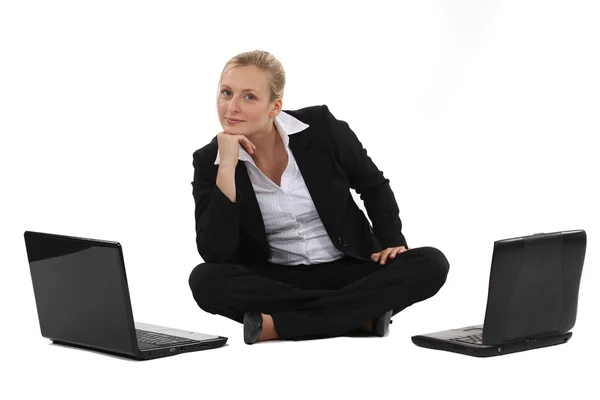 Žena sedí na podlaze s dvěma notebooky — Stock fotografie