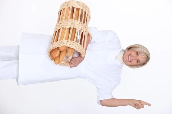 Trabajador de panadería sosteniendo cesta de pan —  Fotos de Stock