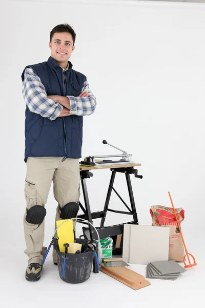 Торговец позирует со своими инструментами и строительными материалами — стоковое фото