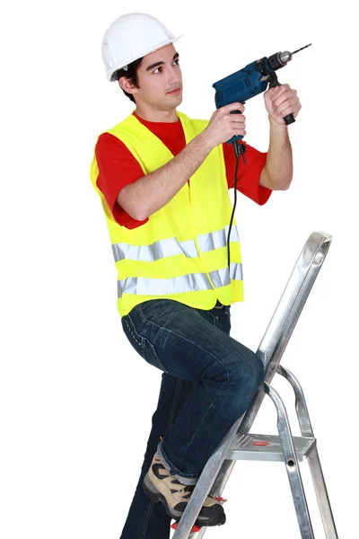 Man met boor terwijl stond op de ladder — Stockfoto