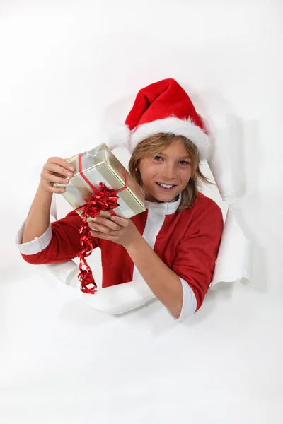 Chlapec, oblečený jako santa s dárkem — Stock fotografie