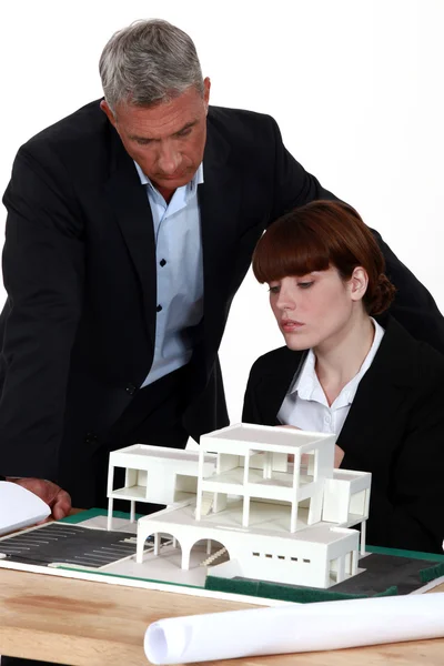 Arquitecto y asistente mirando la casa modelo —  Fotos de Stock