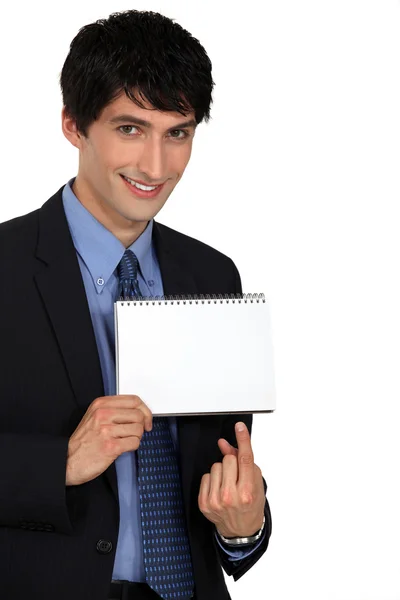 Empresário apontando para um bloco de notas em branco — Fotografia de Stock