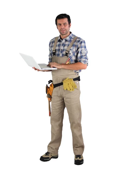Tradesman in possesso di un computer portatile — Foto Stock