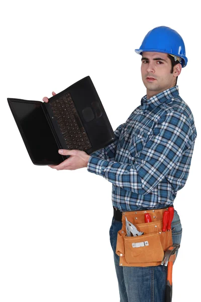 Handwerker blickt auf die Unterseite seines Laptops — Stockfoto