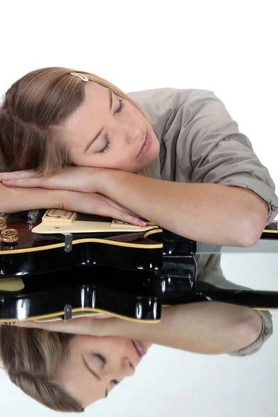 Jeune femme endormie sur sa guitare — Photo
