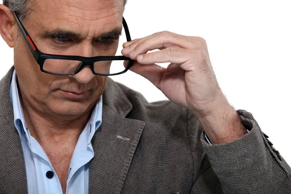 Sénior colocando em seus óculos — Fotografia de Stock