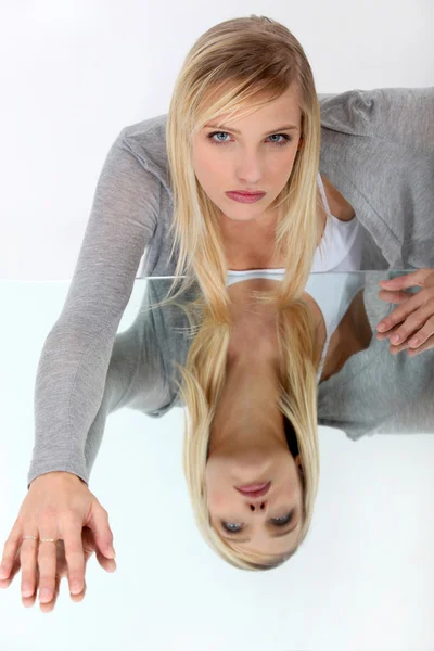 Blondine lehnt sich an reflektierende Oberfläche — Stockfoto